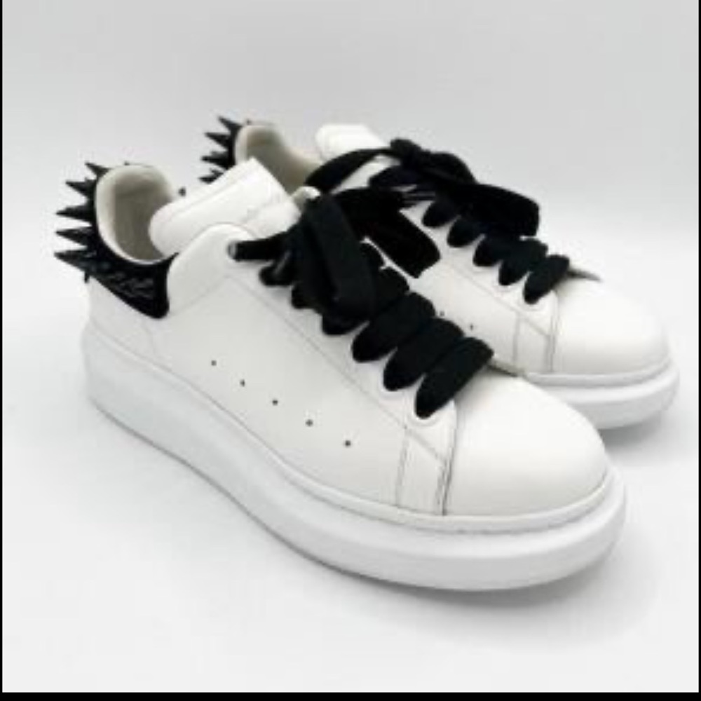 White AlexanderMcQuern sneakers with black studs.
